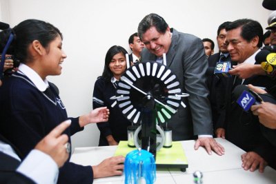 En el laboratorio de física el Presidente observa sonriente la explicación de una alumna carvajalina