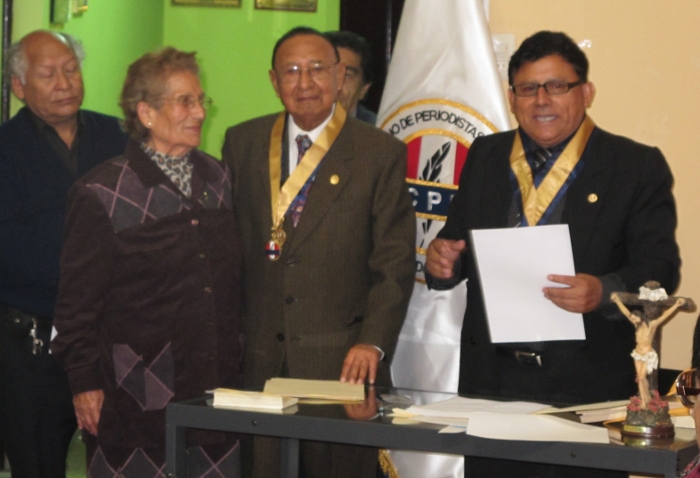 Instante en que el Sr. decano Oscar Olórtegui Chávez, lee el texto del diploma de honor que entregará al Licenciado Rodolfo Velarde que cumple 50 años al servicio de la noble profesión del periodismo. Lo acompaña su esposa Julia Aparicio de Velarde