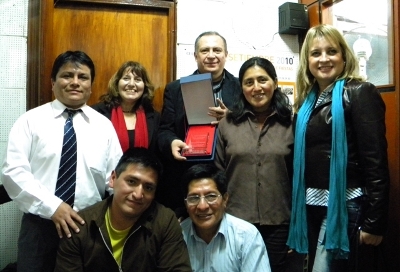Aparece el dinámico director Kevin Enequé, Mary Vizcarra (RR.PP.), Dr. Hugo Guerra, con la Placa "SIMBOLO EJEMPLAR DEL PERIODISMO NACIONAL", América Pévez,la esposa del Dr. Guerra. Abajo Yojhan Lindo y Pepe Encalada