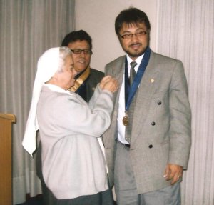 El escritor Rafael Saavedra, recibe una insignia, señal de éxitos, de manos de una religiosa bajo la atenta mirada del señor Decano del Colegio de Periodistas de Lima